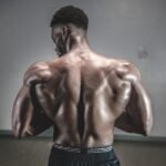 A shirtless man displaying his muscular back, showcasing strength and fitness.