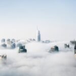 A stunning view of Dubai skyscrapers emerging through a blanket of fog, showcasing modern architecture.