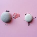 Charming stone art with heart symbol on pink background, symbolizing love and connection.